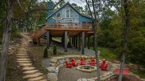 Une cabane dotée d’une terrasse, d’un escalier en pierre et de sièges d’extérieur.