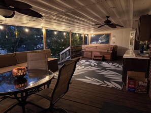 An outdoor patio area with a seating arrangement, a table, and a ceiling fan.