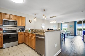 Enjoy cooking in this well-equipped kitchen with a microwave, oven, and dishwasher, and dine in the adjacent dining area with a view of the outdoors.