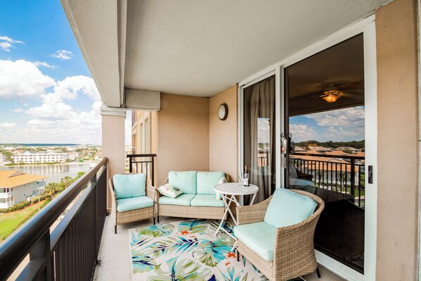 Relax on the balcony with a sofa, armchairs, and a small table, taking in the views of the surrounding water and buildings.