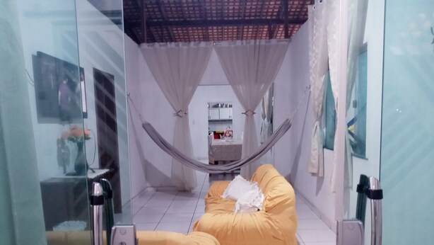 A room with a bed, a small table, and a mirror. - Casa na Praia do Atalaia em Salinas (Salinópolis)