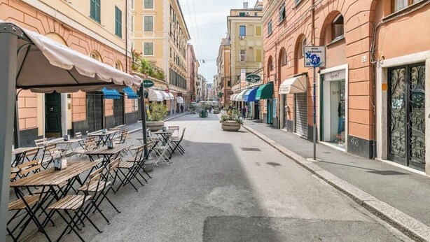 A narrow street with outdoor seating and closed shops.