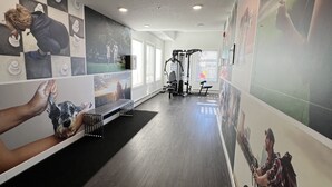 A gym with wooden flooring, exercise equipment, and motivational posters on the walls. - Luxury Airport Suite 2Bed 2Bath w/ heated parking (Calgary)
