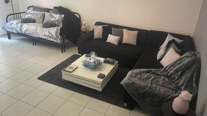 En stue med sofa, sofabord og seng.