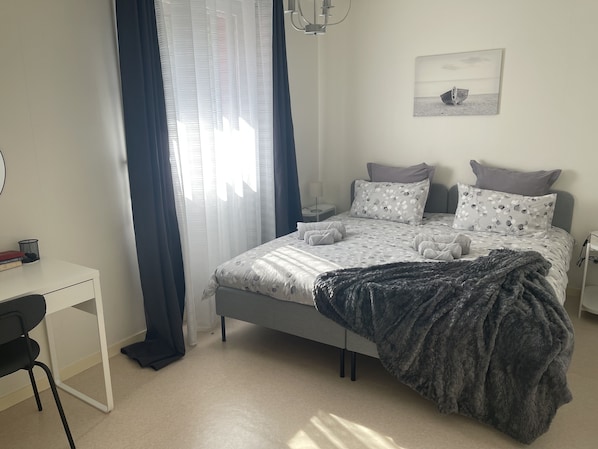 Quarto com cama, escrivaninha e cadeira.