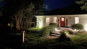Et hus med rødlakerede døre, en lille veranda og et flag.