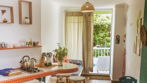 Una cocina con comedor, suelo de madera y vistas a un balcón.