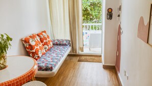 Una habitación acogedora con un sofá, una mesita y una planta en maceta.