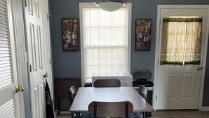 Een eethoek met een tafel, stoelen en een plafondlamp.