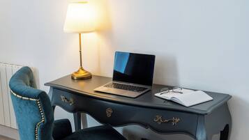 A desk with a laptop, a lamp, and a notebook.
