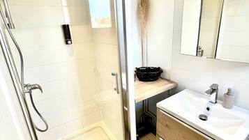 Regadera, secadora de cabello, toallas, papel de baño