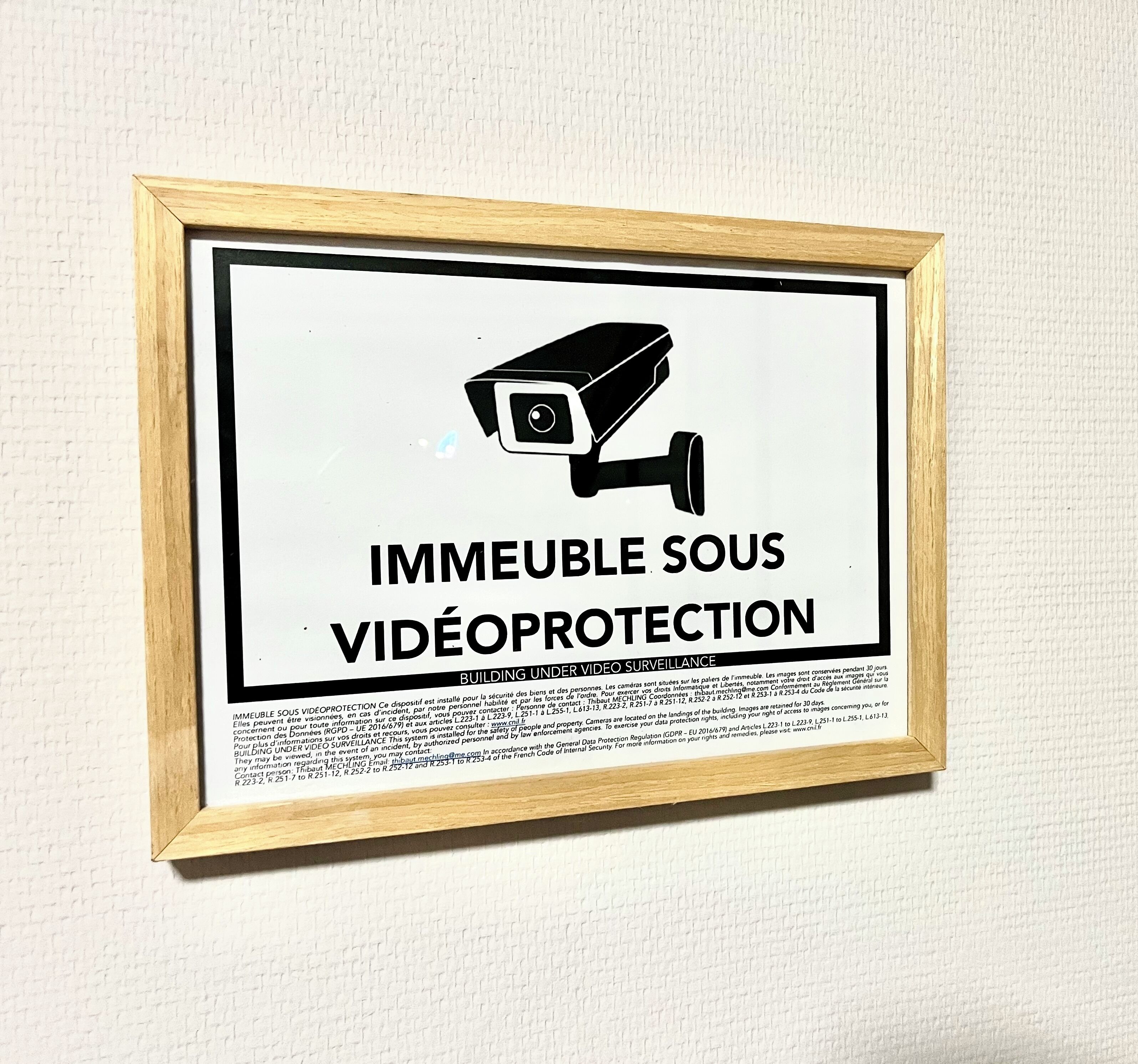 Un cartel enmarcado con el icono de una cámara de vigilancia y el texto 