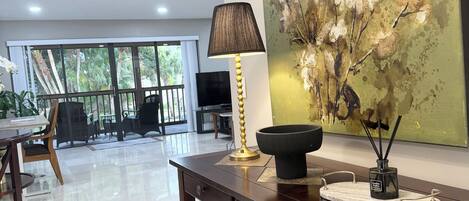 Una sala de estar moderna con comedor, un ventanal grande y un cuadro decorativo.