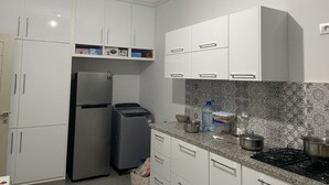 A kitchen with white cabinets, a stainless steel refrigerator, a gas stove, and a patterned backsplash. - Built in 2024, Sea view (sousse)