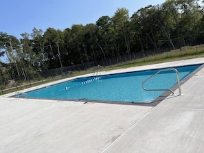 Piscina rectangular con una escalera y un pasamanos metálicos en un lateral.