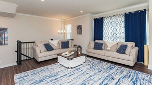 Ein Wohnzimmer mit zwei Sofas, einem Couchtisch und einem Teppich mit Muster.