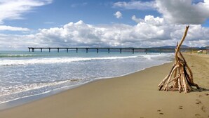 Une plage avec une structure en bois et une jetée en arrière-plan.