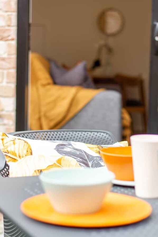 Una preparación para el desayuno con una taza, un bol y un plato sobre una mesa.