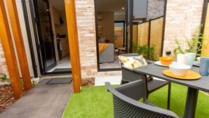 An outdoor patio area with a table set for dining, a sofa, and a small seating area.