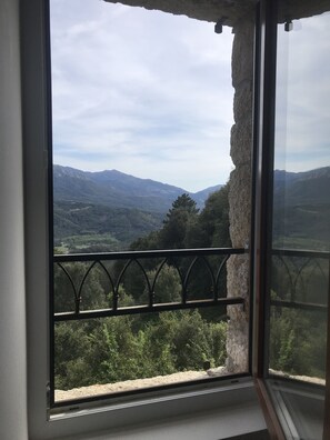 Janela com vista para uma paisagem montanhosa.