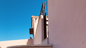 Una serie di gradini in cemento all'aperto che conducono a un edificio, con ringhiera in metallo.