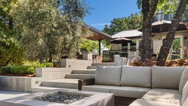 A modern outdoor living area with a sectional sofa, a fire pit, and a covered patio. - Healdsburg Modern home, 3BR/3.5BA pool, hot tub, outdoor kitchen, WiFi (Healdsburg)