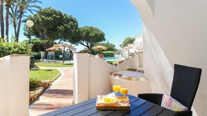 A patio with a table, a basket of fruit, and two glasses of orange juice. - Calahonda 2BED apartment - great location (Mijas Costa)