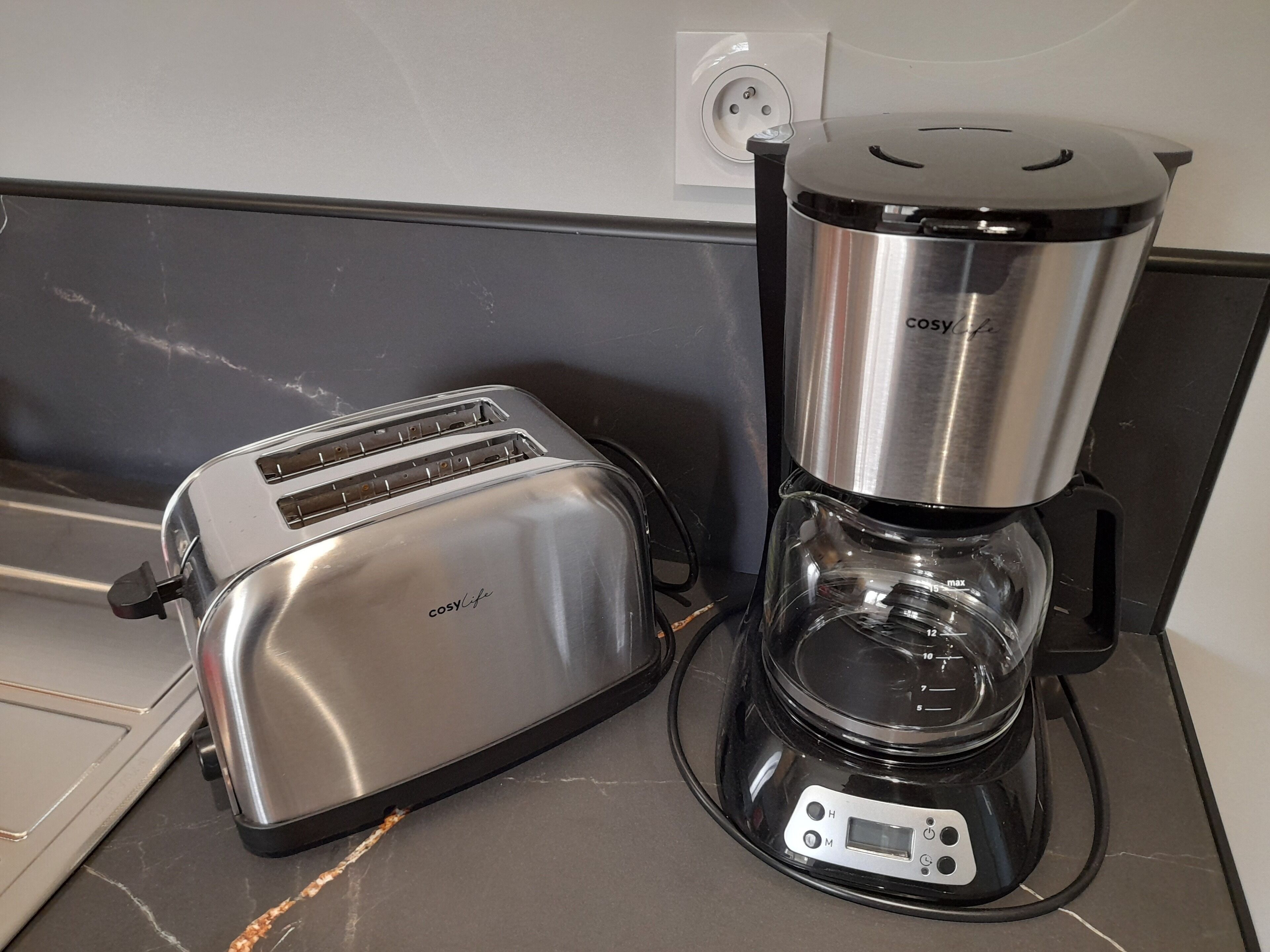 Et køkken med en ristovn og en kaffemaskine på bordet.