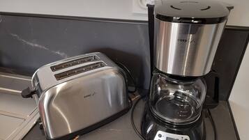 A kitchen with a toaster and a coffee maker on the counter.