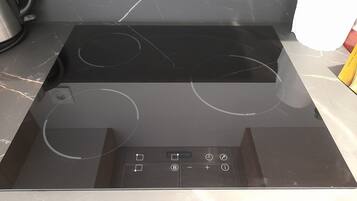 A black stovetop with four burners and a digital control panel.