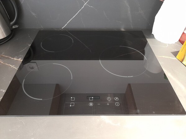 A black stovetop with four burners and a digital control panel.