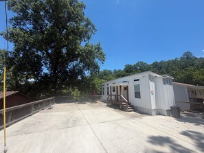 A single-story building with a covered porch and a staircase leading to the entrance. - Tiny House on Center Hill Lake (Baxter)