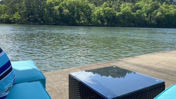 A view of a lake with a dock and a table in the foreground. - Marvel Lake House Too (Hot Springs)