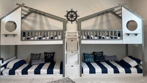 A bunk bed room with a ceiling fan, a ship's wheel decoration, and a ladder. - Marvel Lake House Too (Hot Springs)