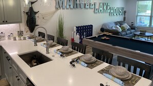 A modern kitchen with a large island, a pool table, and a dining area. - Marvel Lake House Too (Hot Springs)