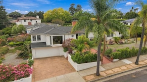 A residential property with a garage, landscaped garden, and a variety of plants.