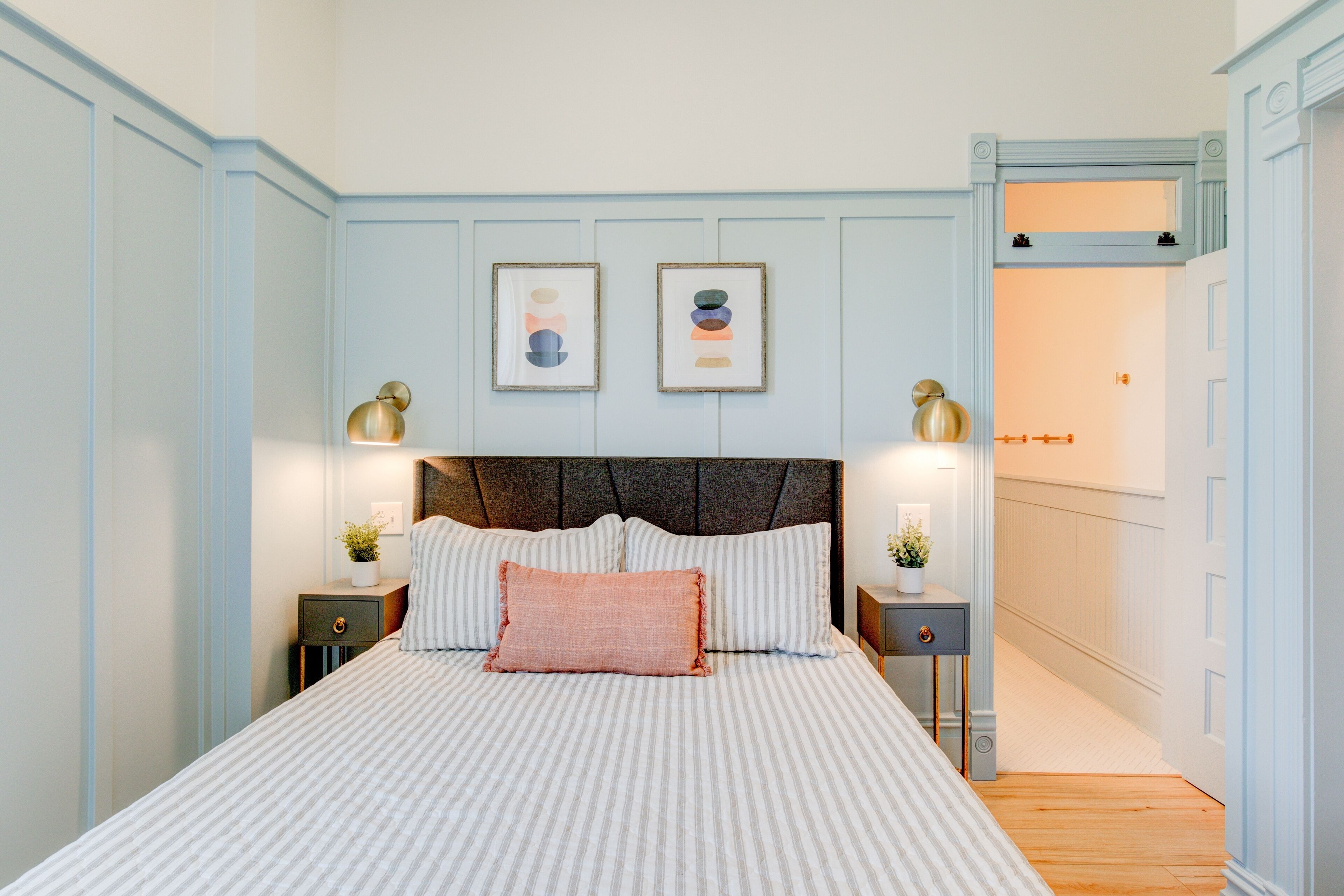 Un dormitorio ordenado con una cama grande, dos mesitas de noche y un cabecero.