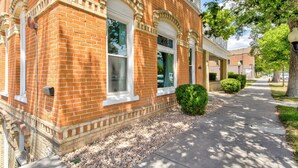 A brick building with large windows and a sidewalk. - Art City Inn (Springville)