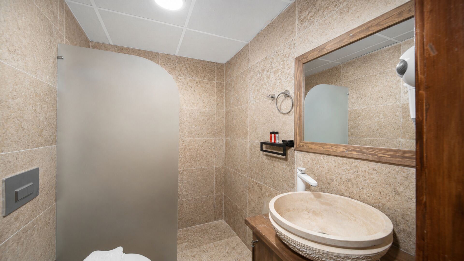 Une salle de bain avec une douche, un lavabo et un miroir.