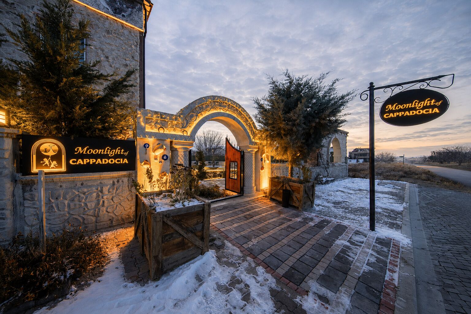 A hotel entrance with a stone facade, an arched doorway, and a sign reading 'Moonlight of Cappadocia.'