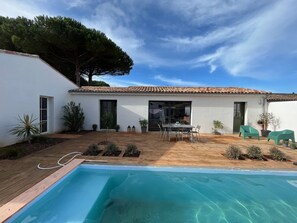 A white building with a tiled roof, a pool, and outdoor seating. - Maison Neuve Idéale Pour les Familles, Proche Océan et Centre Village (Le Bois-Plage-en-Ré)