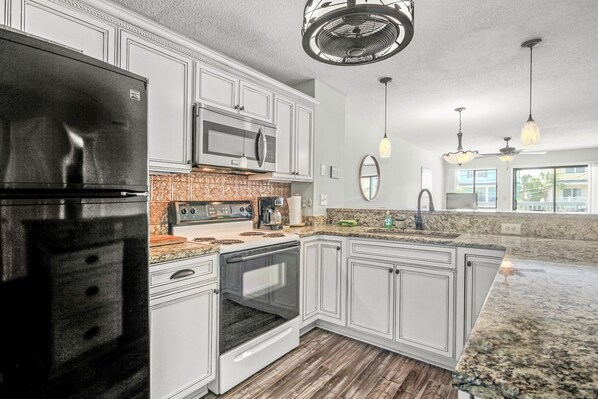 Enjoy cooking in this well-equipped kitchen with an oven, microwave, and large island with sink and ample counter space.