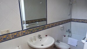 A bathroom with a pedestal sink, a toilet, a bidet, and a bathtub. - Hotel Mestas (Cabrales)