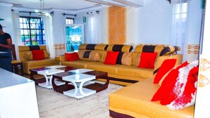Una sala moderna con un conjunto de sofás, dos mesas auxiliares y un comedor.