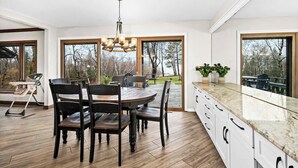 Una cocina moderna con comedor, ventanas amplias y vistas al exterior.