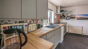 A modern kitchen with wooden countertops, a kettle, a toaster, and a stove. - 2 bedroom accommodation in Rye (Rye)