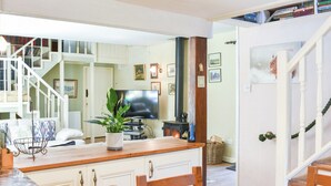 A cozy living room with a wooden dining table, chairs, a TV, and a fireplace. - 2 bedroom accommodation in Snaizeholme, near Hawes (Snaizeholme, near Hawes)