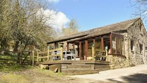 A rustic stone building with a wooden deck and outdoor seating area. - 2 bedroom accommodation in Snaizeholme, near Hawes (Snaizeholme, near Hawes)