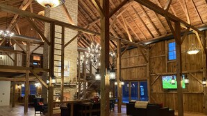 Un loft spacieux avec de hauts plafonds, des poutres apparentes et un coin salon confortable doté d’une cheminée.