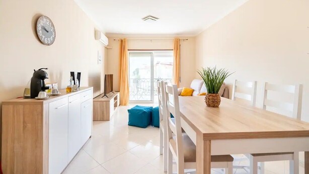 A modern kitchen with a wooden countertop, a coffee machine, and a clock on the wall. - White House (Altura)